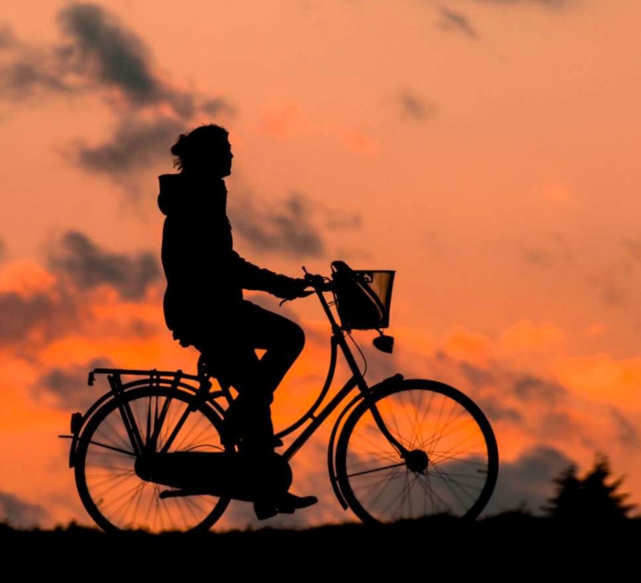Silhuett av cyklist i solnedgång.
