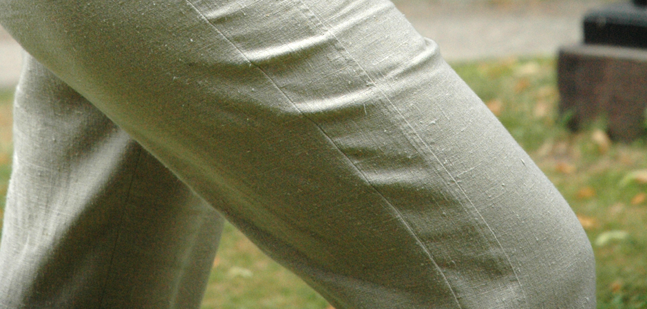Närbild av ett par ben i beiga byxor.