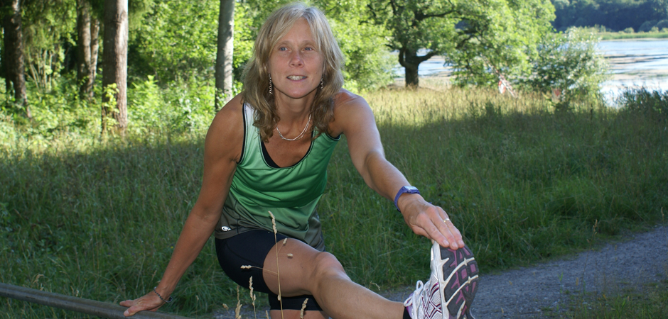 Arbetsterapeuten Eva Fransson stretchar hukandes i en grönskande miljö