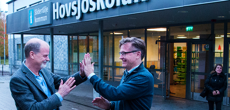 Lasse Fröidstedt och Håkan Malmrot gör high five utanför Hovsjöskolan.