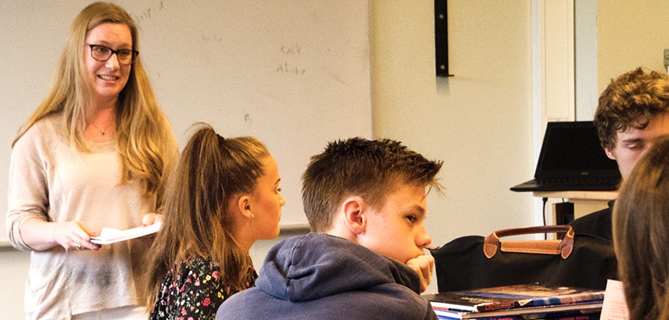 En lärare och barn samtalar i ett klassrum