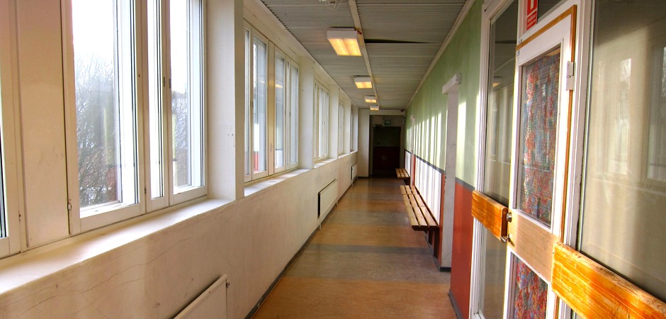 En tom korridor med fönster på vänster sida