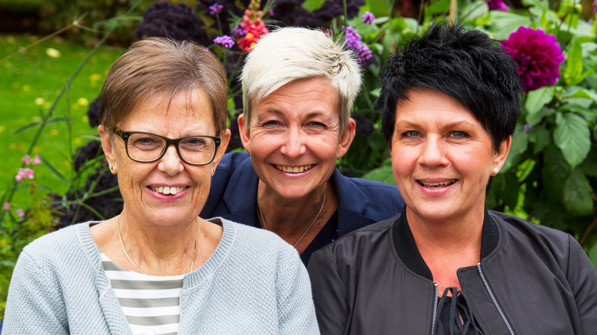 Närbild på tre leende kvinnor, Elisabet Björklund, Marie Niljung och Ingela Persson, i park med blommor i bakgrunden