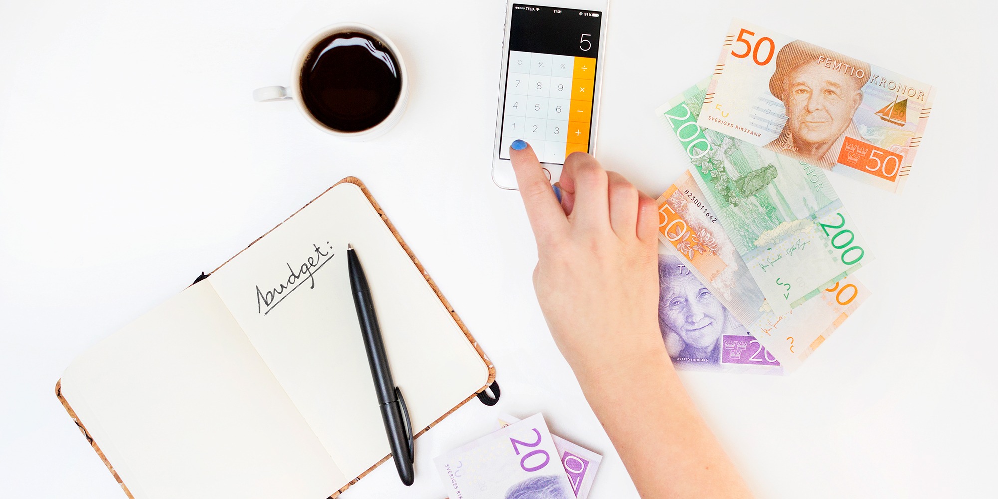 arrangerad bild mot vit bakgrund med pengar, en hand som pekar på en miniräknare, ett anteckningsblock och en kopp kaffe. Allt sett ovanifrån.