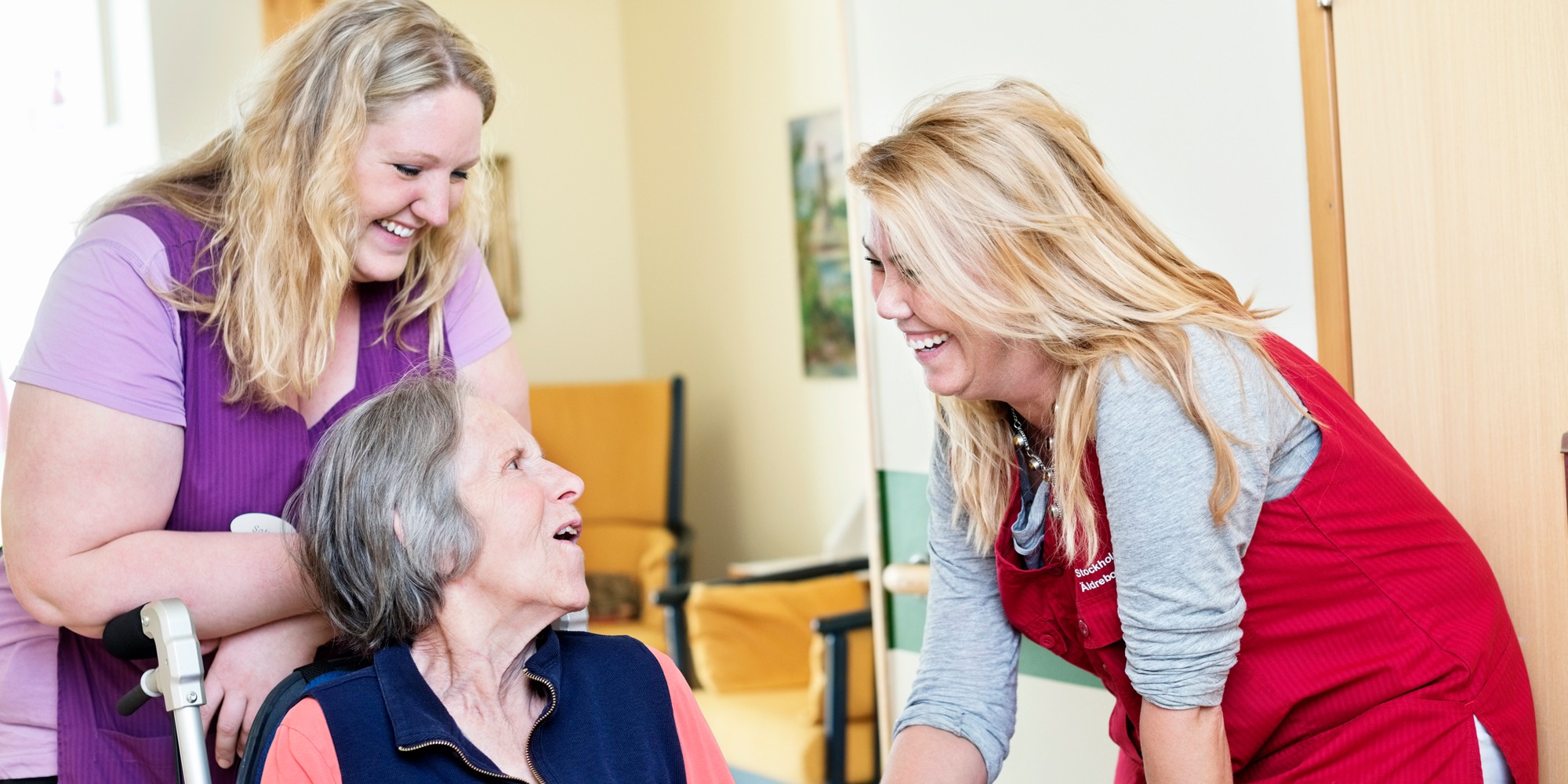 Glad vårdpersonal med äldre sittande kvinna, tema psykisk ohälsa