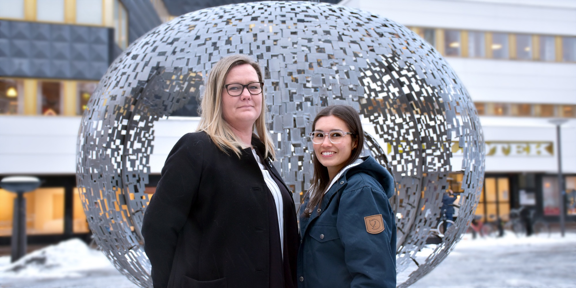 Susanne Hedlöf och Yvonne Åkerlind utomhus framför rund staty, organisatorisk och social arbetsmiljö