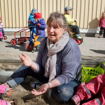 lena berggren förskollärare i Sundsvall, sitter i en sandlåda tillsammans med förskolebarn