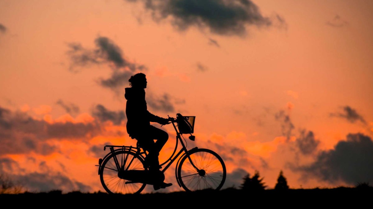 Cyklist i solnedgång har sund levnadsvana som kan mätas i arbetshälsoekonomiskt analysverktyg.