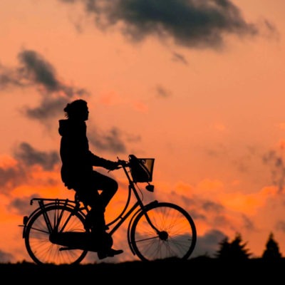 Cyklist i solnedgång har sund levnadsvana som kan mätas i arbetshälsoekonomiskt analysverktyg.