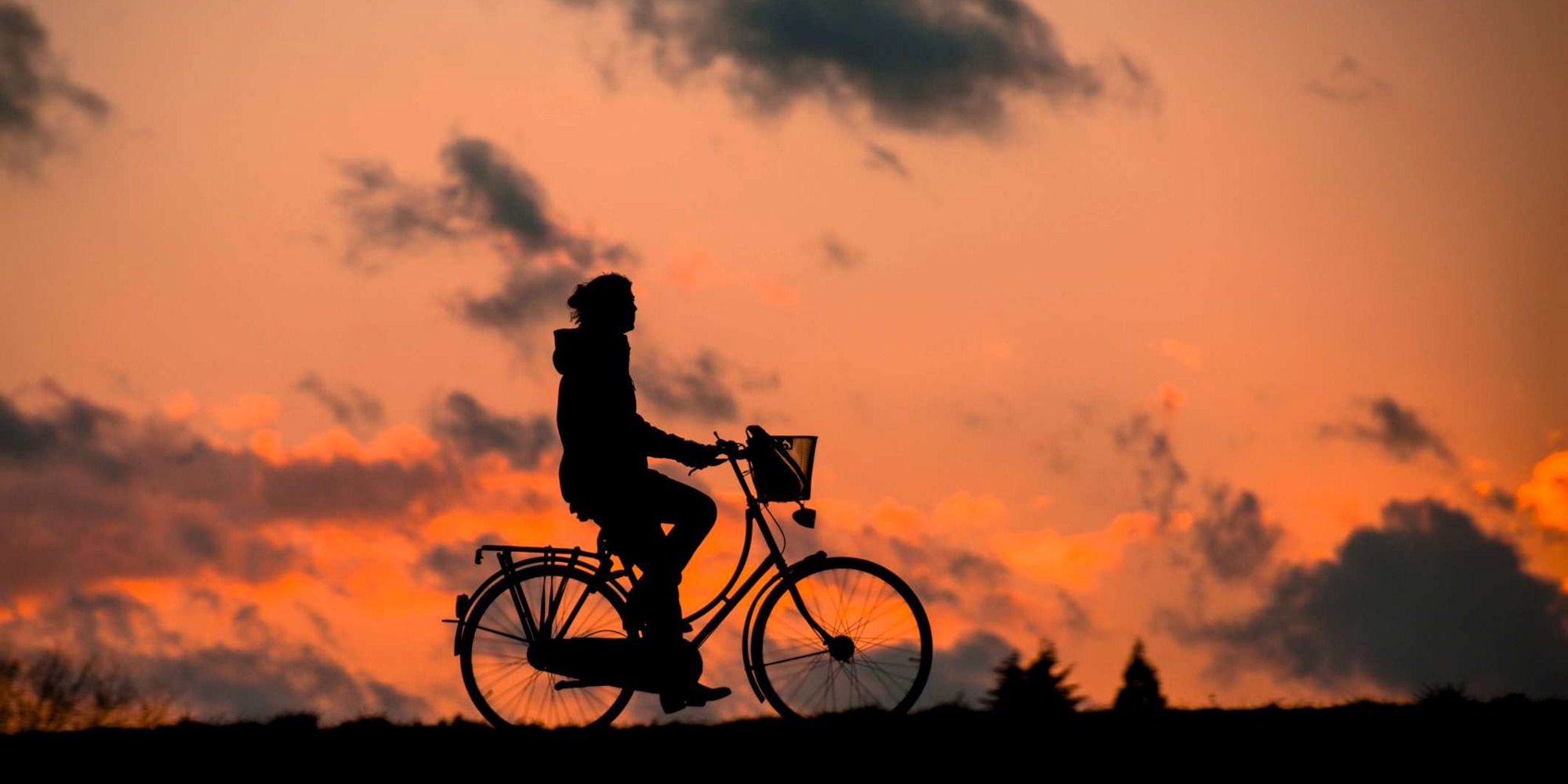 Cyklist i solnedgång har sund levnadsvana som kan mätas i arbetshälsoekonomiskt analysverktyg.