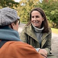 Två kvinnor samtalar utomhus, tema återhämtning.