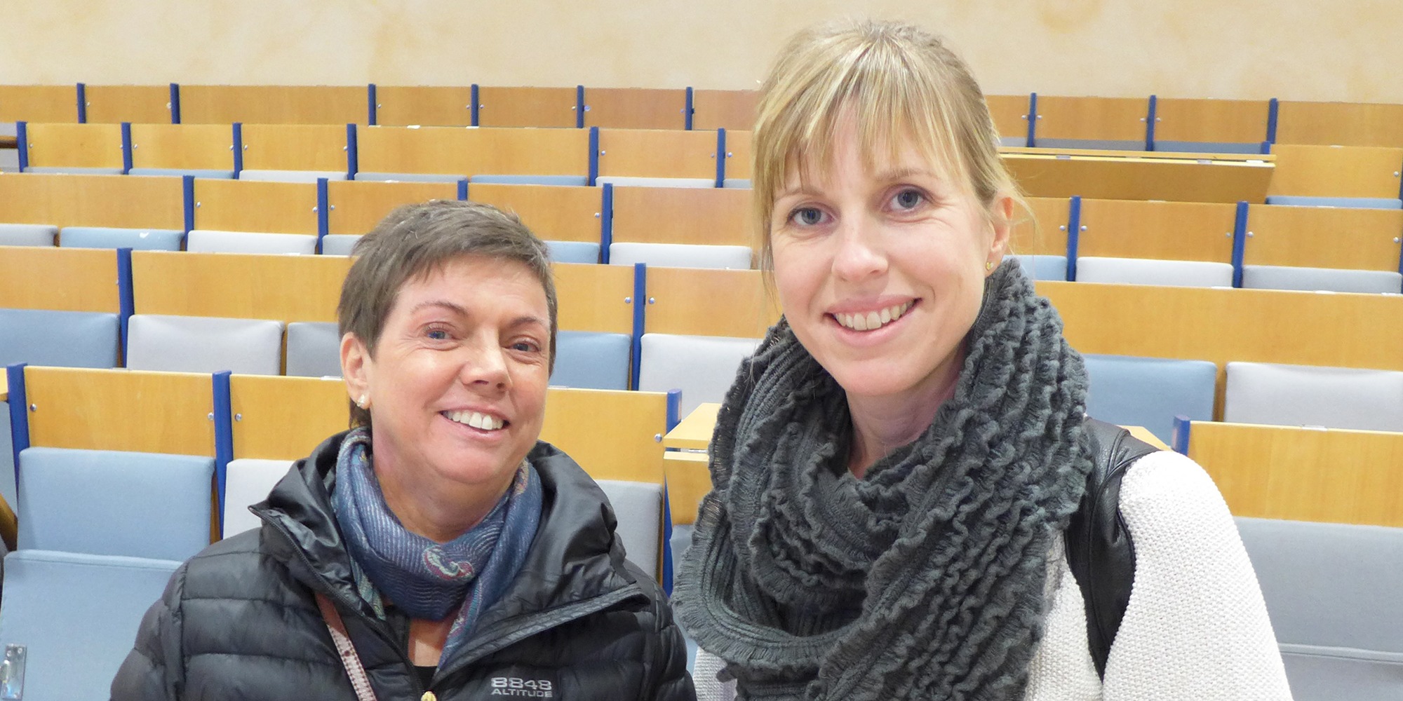 Ann Hammar Blomqvist och Lotta Winberg, skyddsombud i Enköpings kommun. Mot bakgrund av stolsrader i aula.