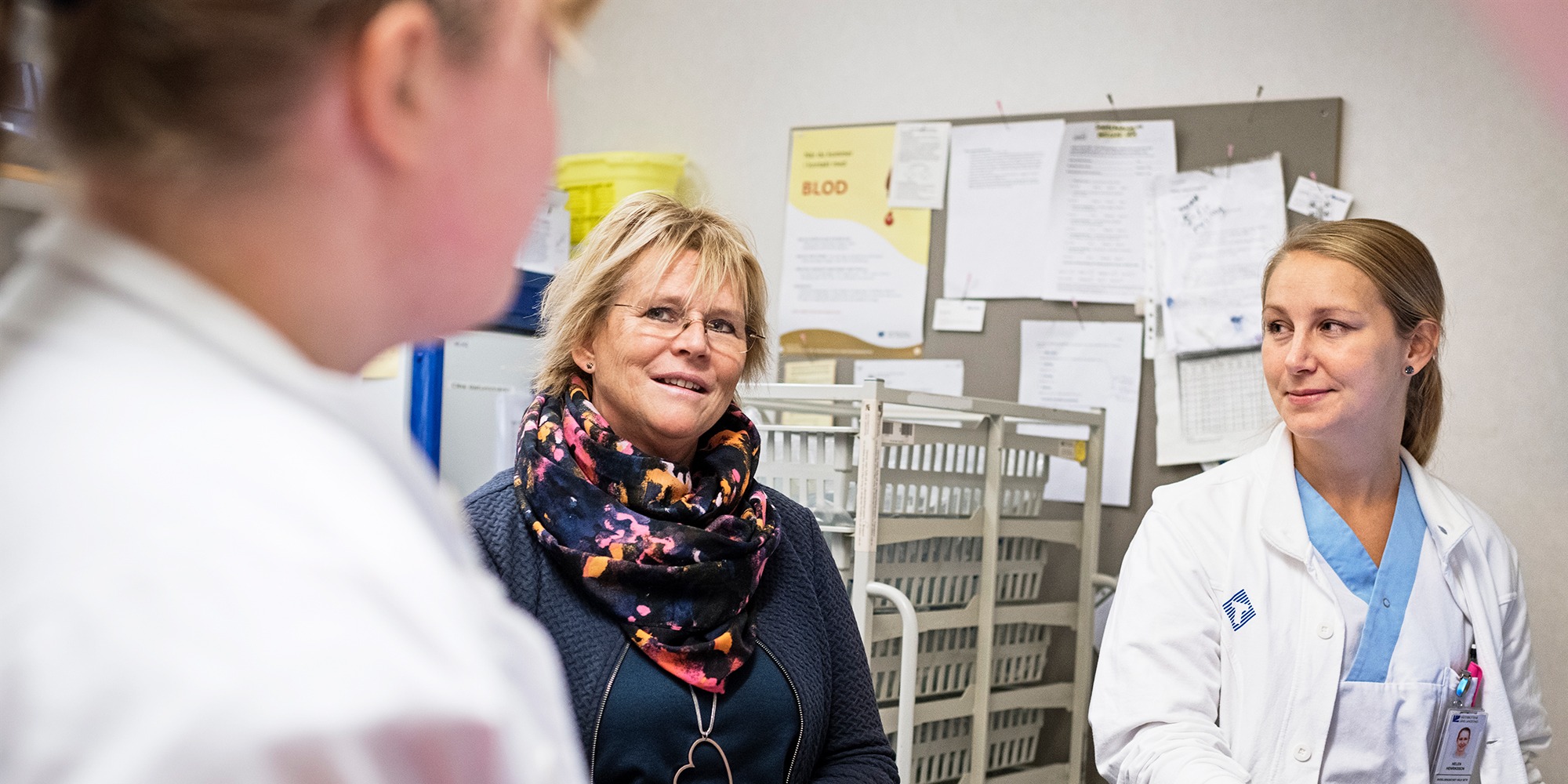 porträtt på tre kvinnor på en sjuksköterskeexpedition på en vårdavdelning. Ulla Olofsson i mitten.