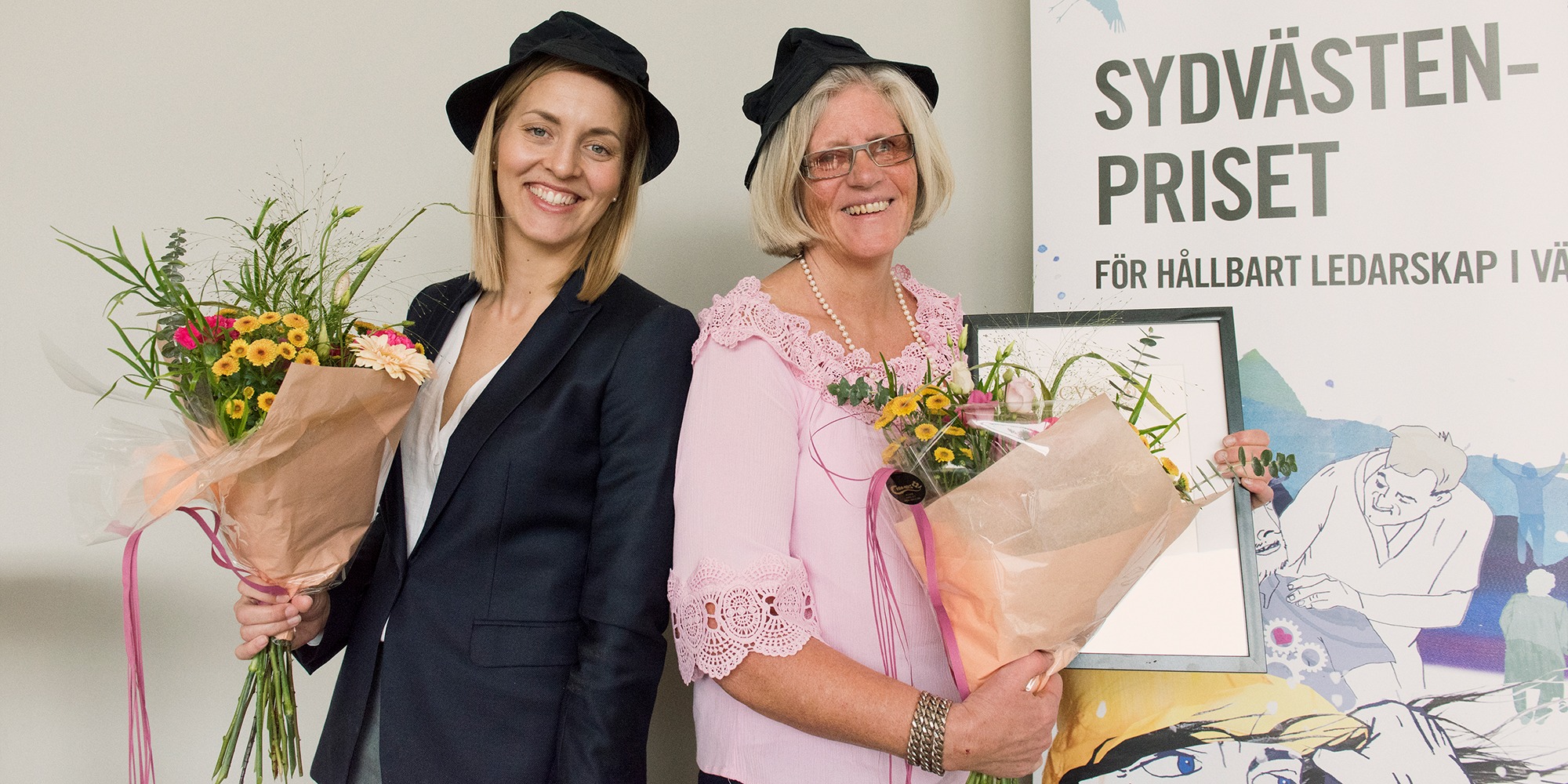Anna Thuresson och Annette Eriksson, chefer i Borås respektive Marks kommun. Två glada kvinnor i svarta hattar, rygg mot rygg , med varsin blombukett.