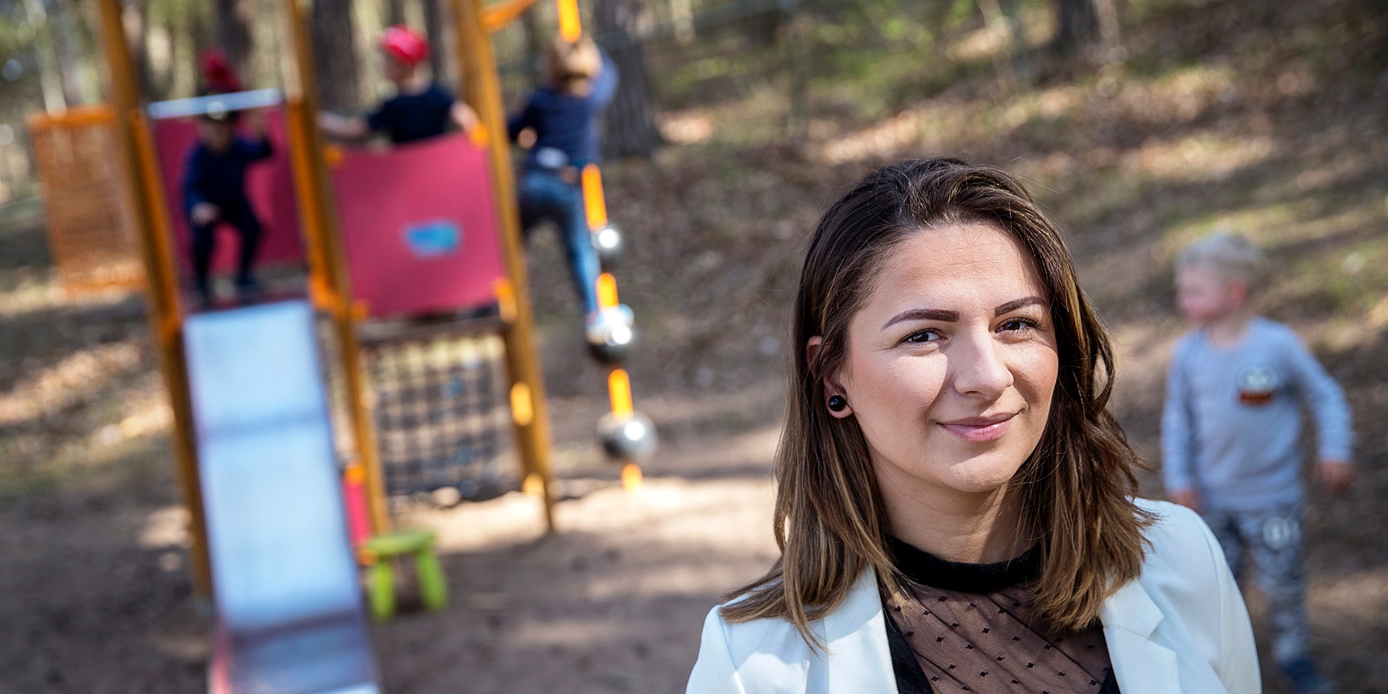 Amra Avdispahic, förskolechef i Mjölby, framför en lekställning med lekande barn.