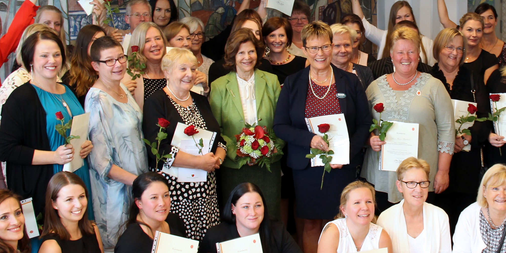Gruppbild på anställda på avd 1 Norrtälje sjukhus tillsammasn med Drottning Silvia i mitten av gruppen.