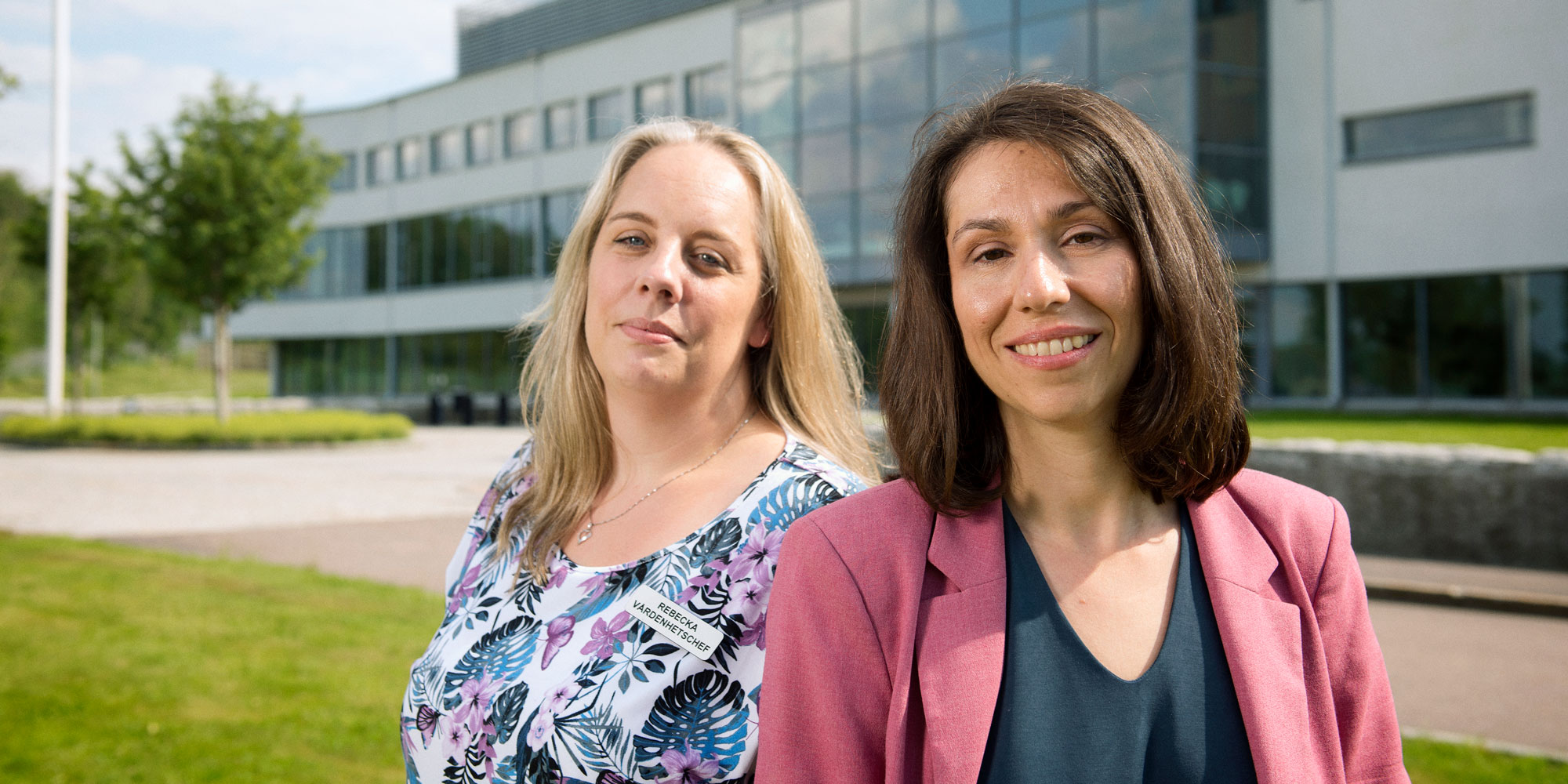 Rebecka Nordh och Eirini Alexiou står rygg mot rygg utomhus utanför rättspsykiatriska vårdenheten Rågården.