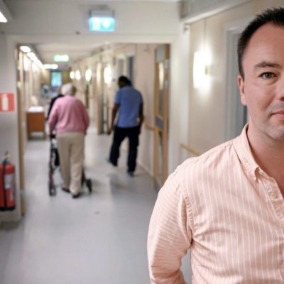 Marcus Gustavsson, chef för ett äldreboende i Göteborg står i en korridor på äldreboendet.