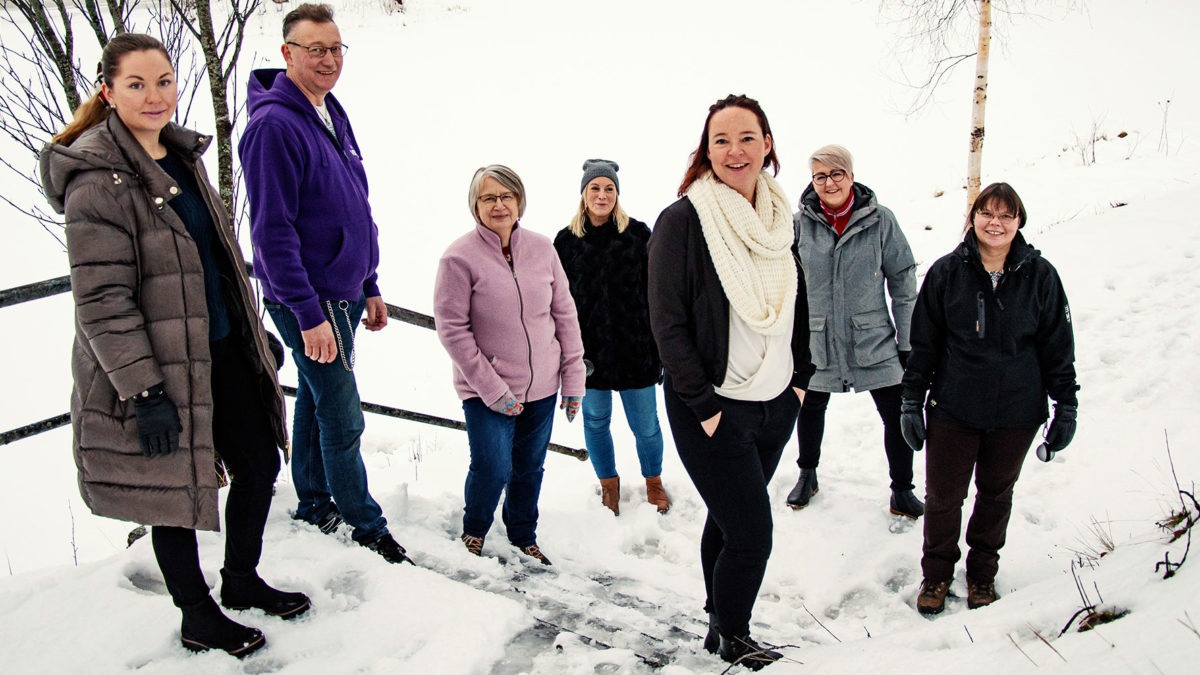 Sju personer från Lyckseles samverkansgrupp står utomhus i en snöig trappa.