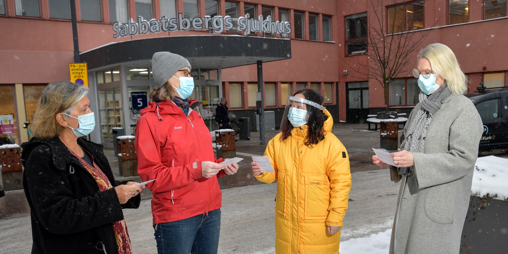Chefer och skyddsombud håller i reflektionskort utanför entrén till Sabbatsbergs sjukhus