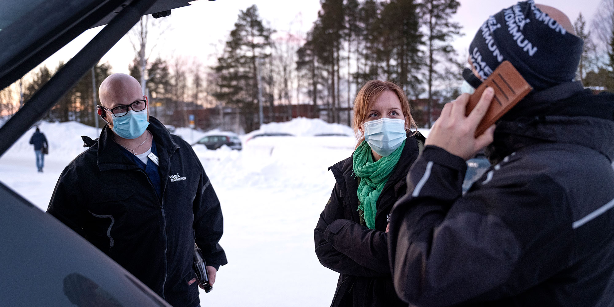 Tobias Ångqvist, Ingela Lundström och Dennis Kallin i samtal vid en öppen baklucka på en bil.