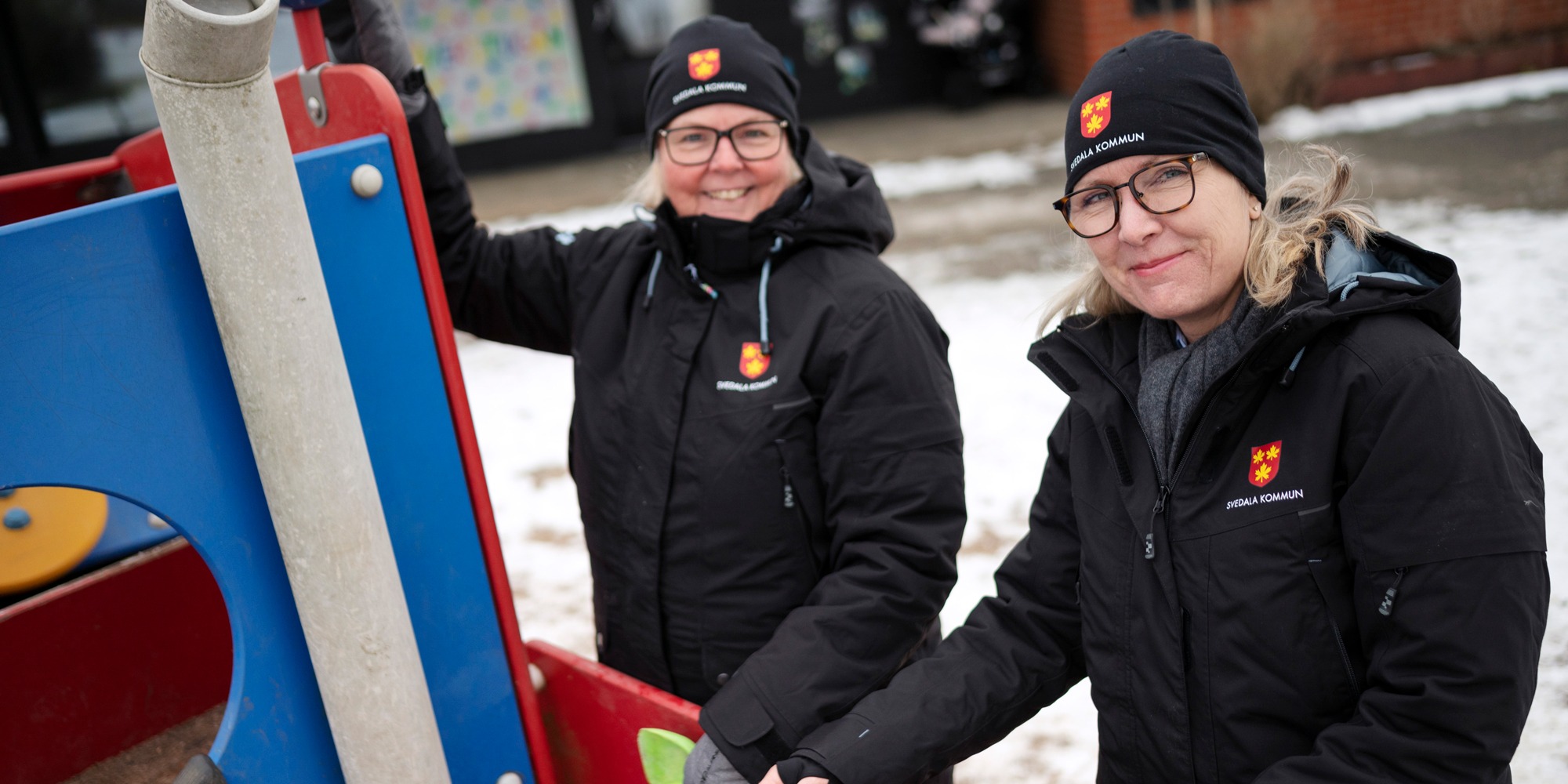 Förskolepersonal och barn på förskolegården