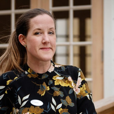 Jenny Häggström lutar sig mot ett räcke utanför sin arbetsplats.