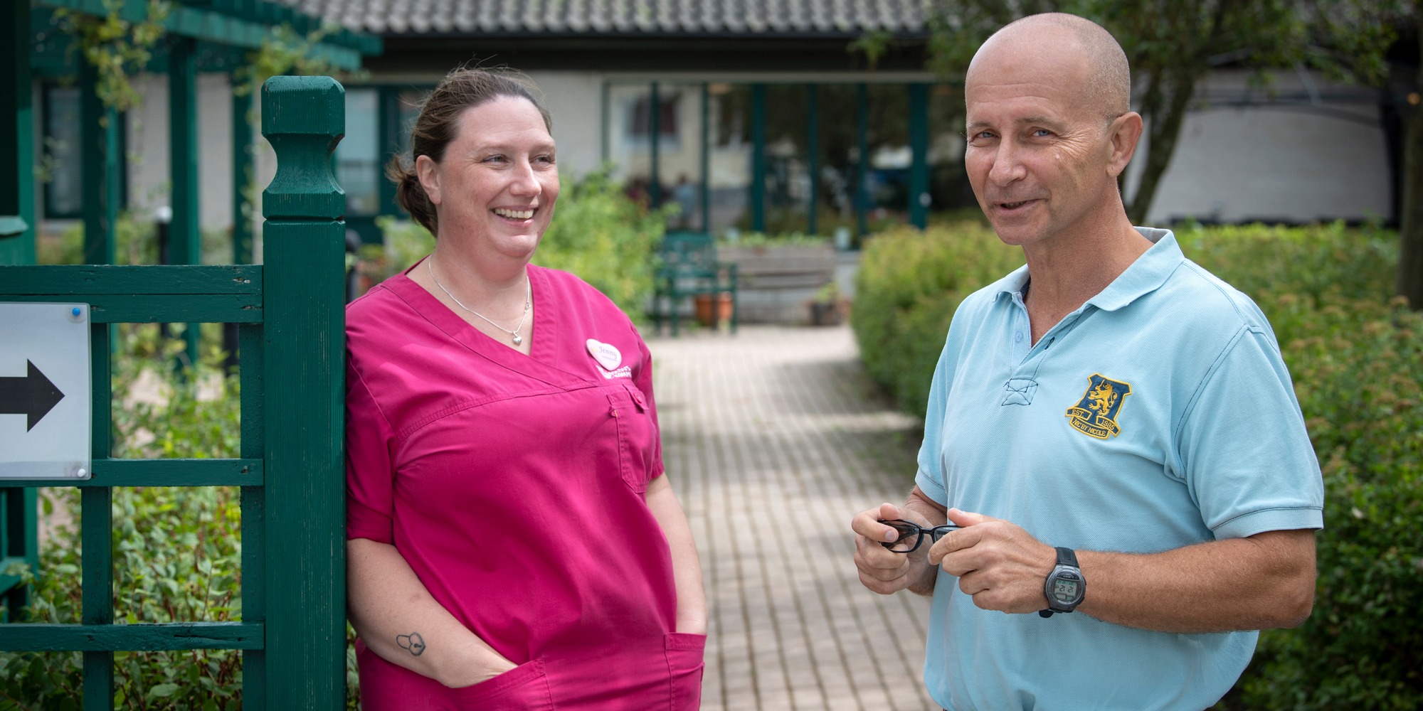 Jenny Nilbecker och Staffan Olsson vid en grind utomhus.