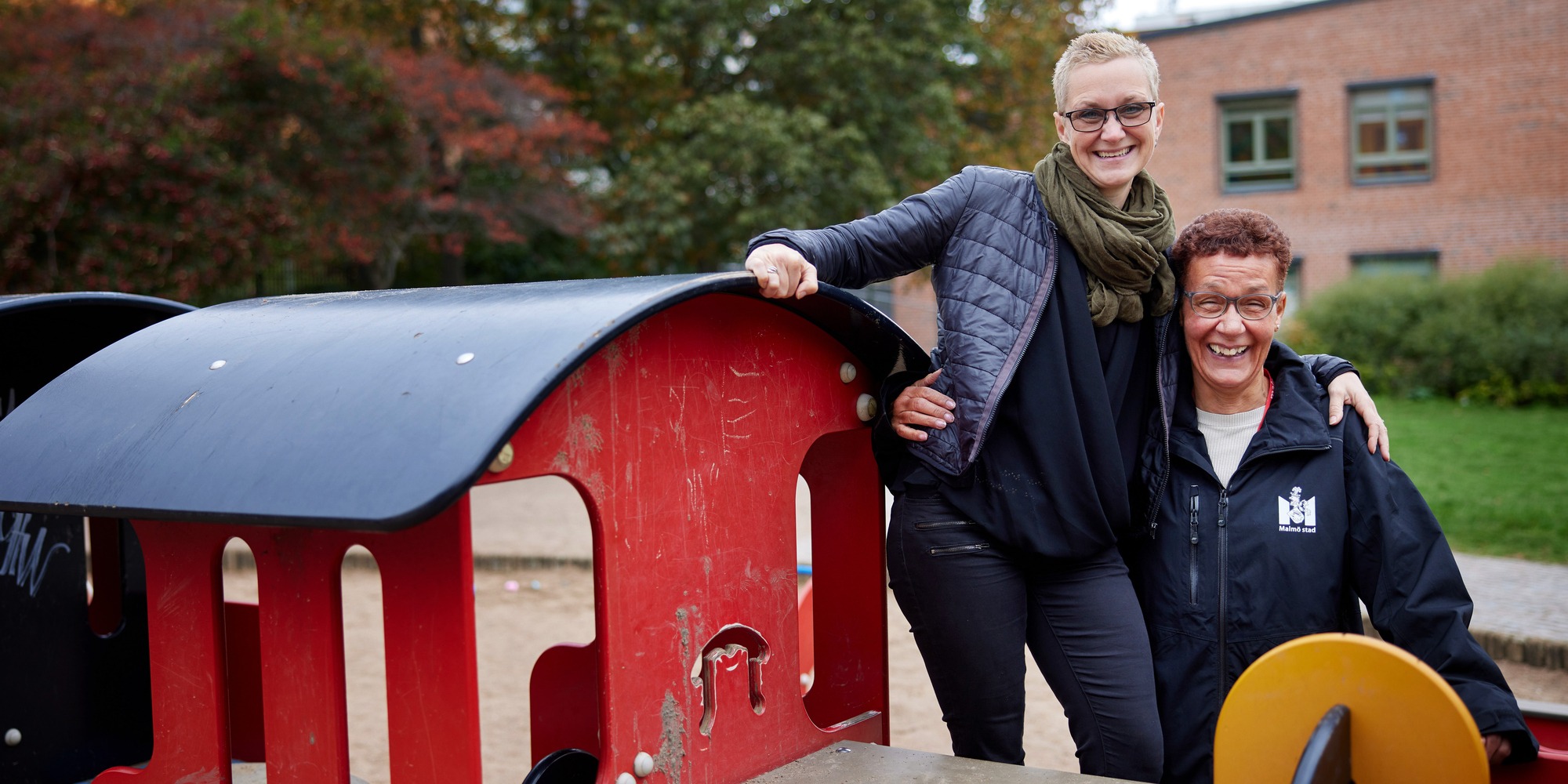 Marie Weedon och Ninni Hyleborg står på ett leksakståg på förskolegården