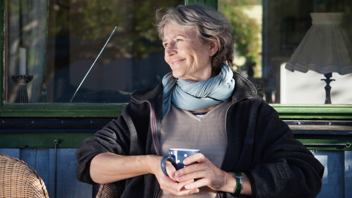 Kvinna sitter och dricker kaffe utomhus