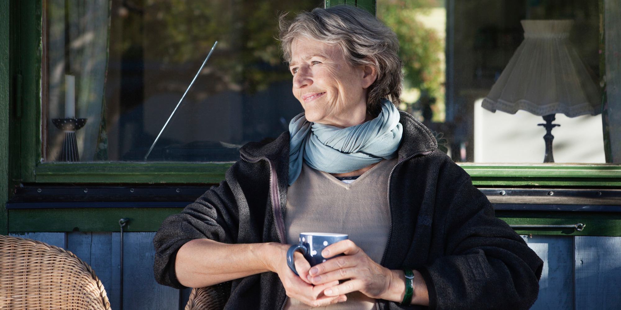 Kvinna sitter och dricker kaffe utomhus