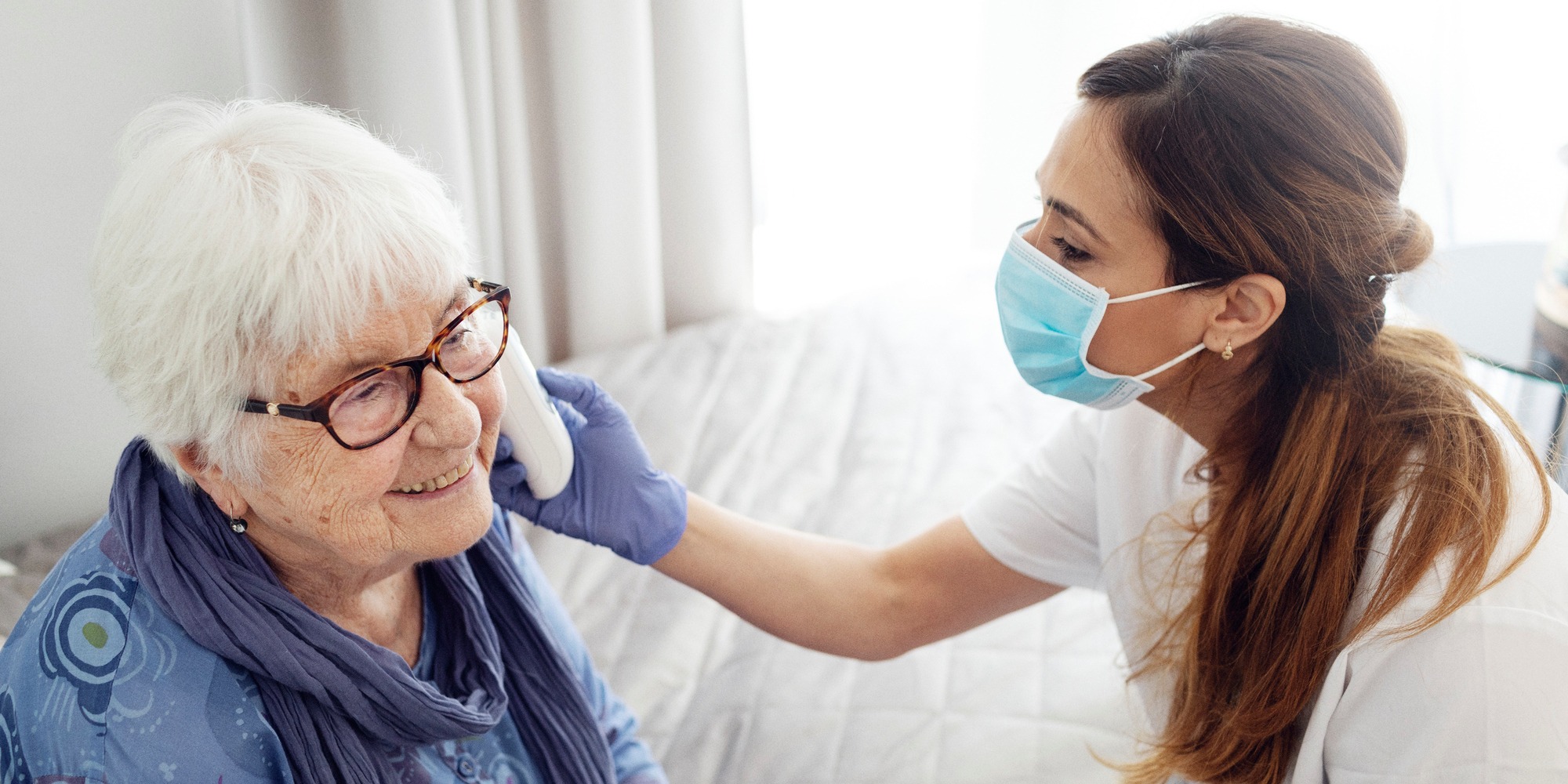 Äldre kvinna får vård av sjuksköterska hemma