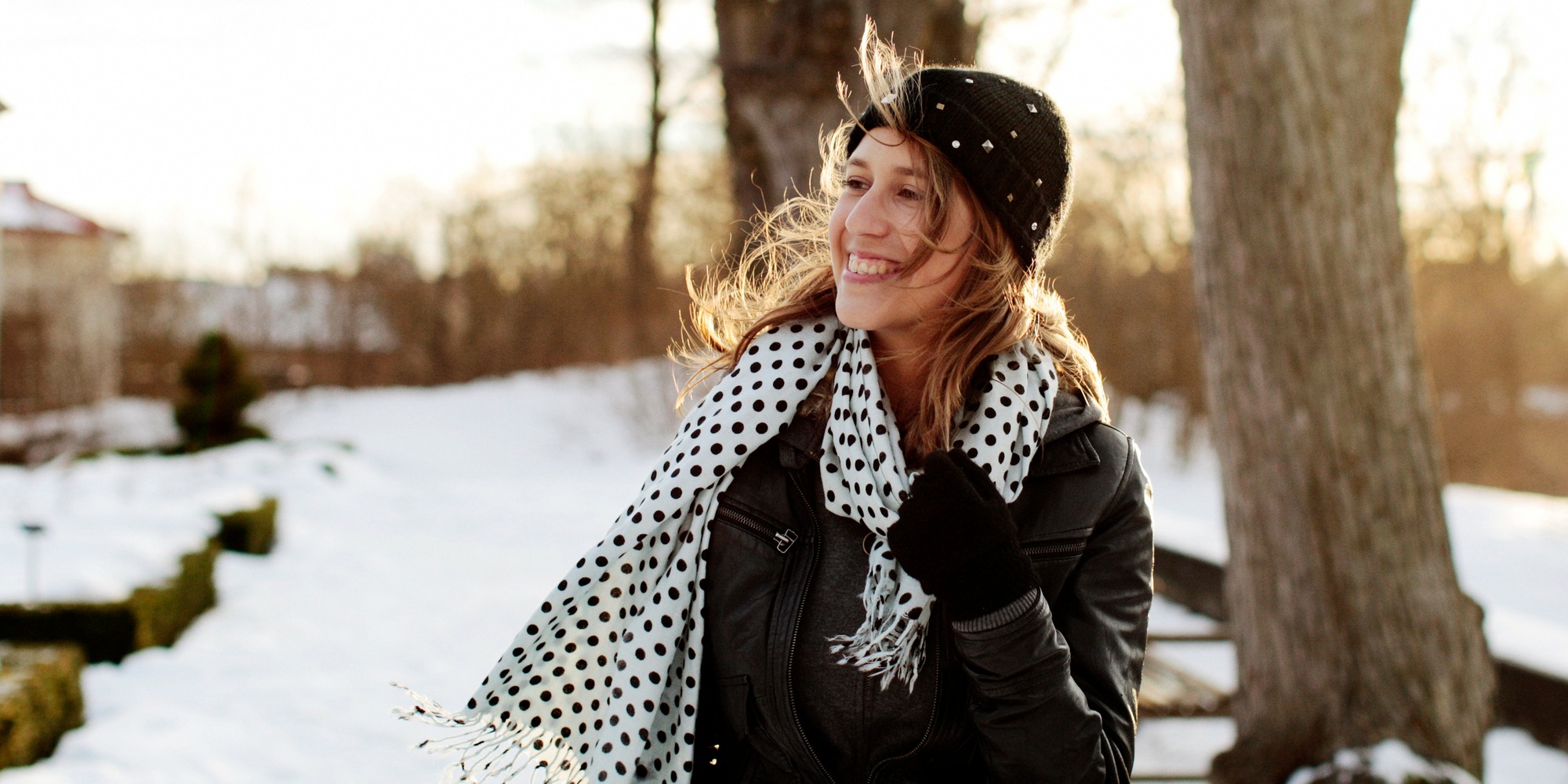 en ung glad tjej med flygigt hår som tar en vinter promenad i solen
