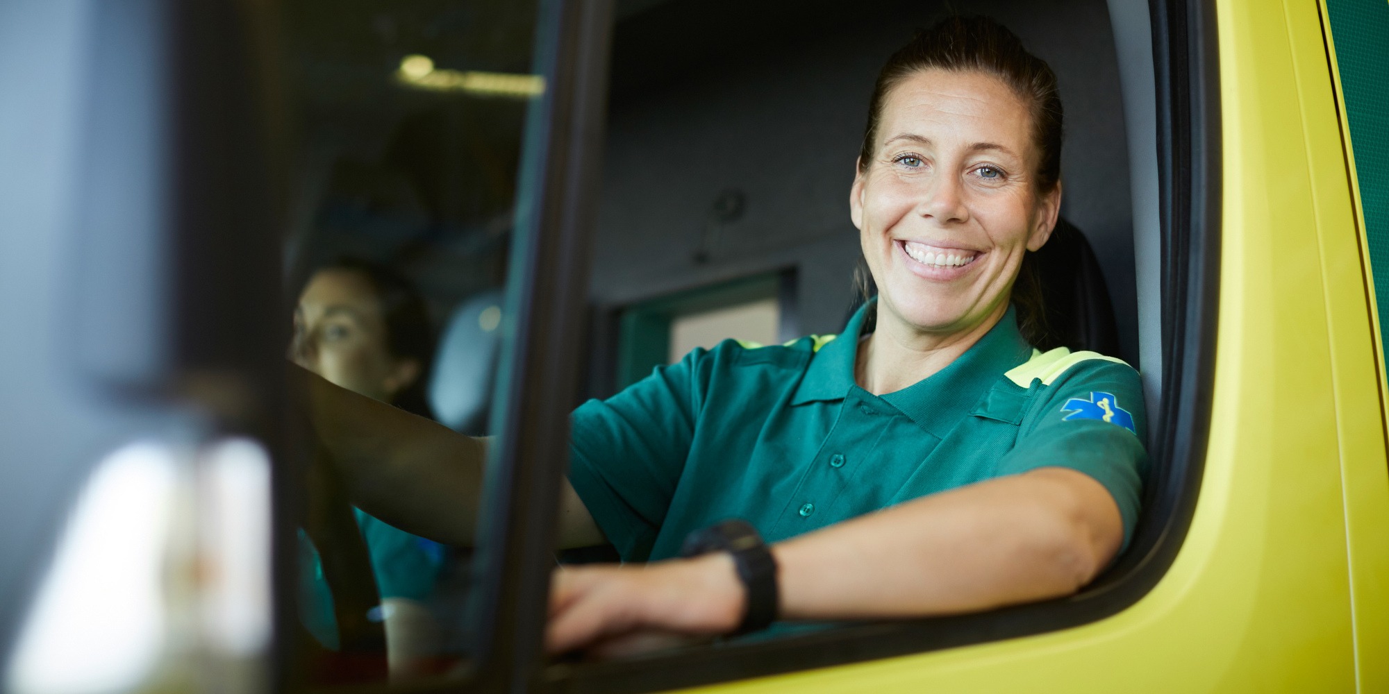 En kvinna sitter vid förarplatsen i en ambulans