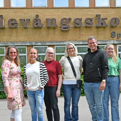 En grupp skolpersonal står uppställda framför Oxievångsskolan