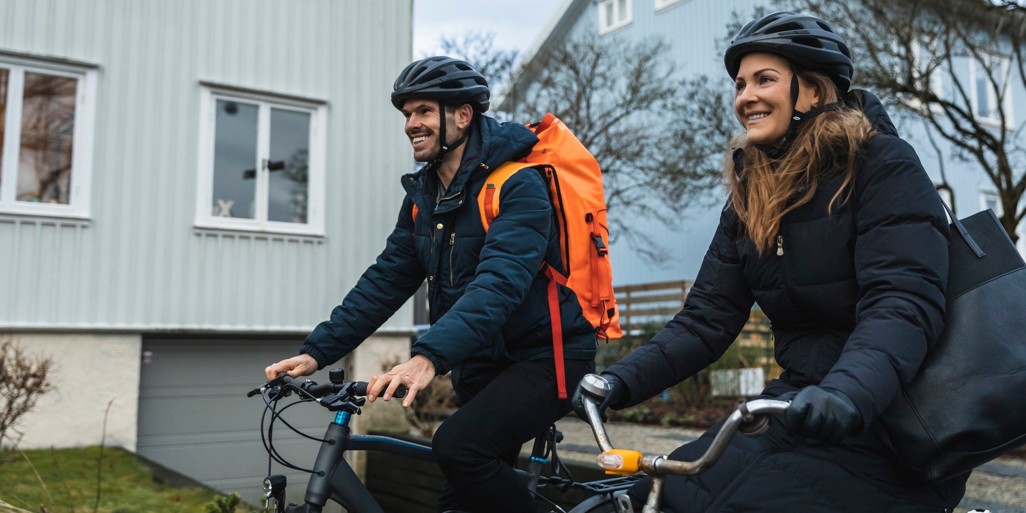 Leende kvinna och man cyklar.