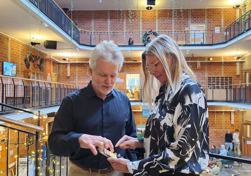 rektor Catrine Hedlund och skyddsombudet Daniel Bengtsson tittar på appen som ska kunna användas vid skolattentat