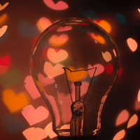 En glödlampa med en massa rosa hjärtan i bakgrunden.