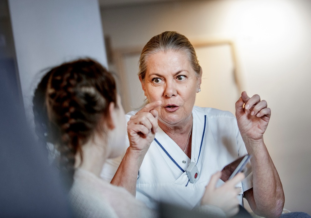 Barnpsykiatripersonal sitter och samtalar med patient.