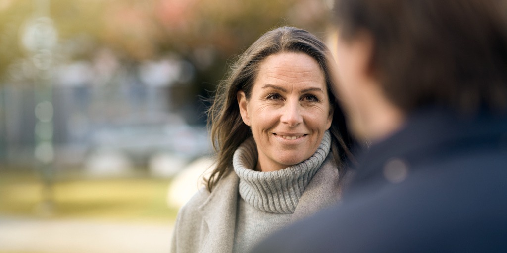 Kvinna talar med arbetskamrat utomhus