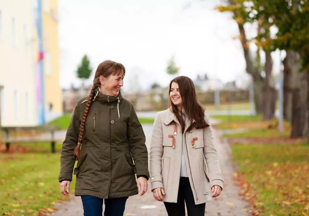 Två kvinnliga kollegor på lunchpromenad, tema hälsa i arbetslivet.