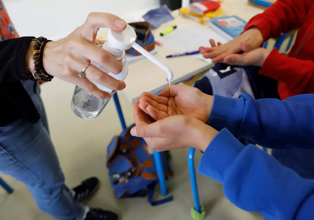 Barnhänder får handsprit ur pumpflaska, åtgärd vid riskbedömning.