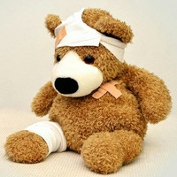 Teddybjörn med plåster och bandage, tema arbetsskada.
