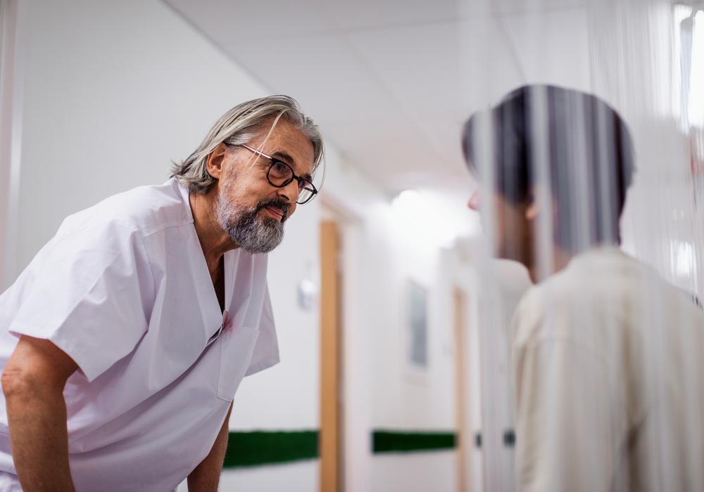 Läkare och patient i korridor på vårdcentral.