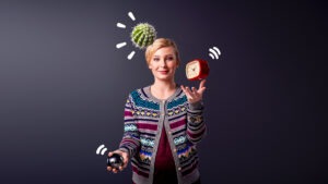 Kvinna jonglerar med väckarklocka, kaktus och boll.