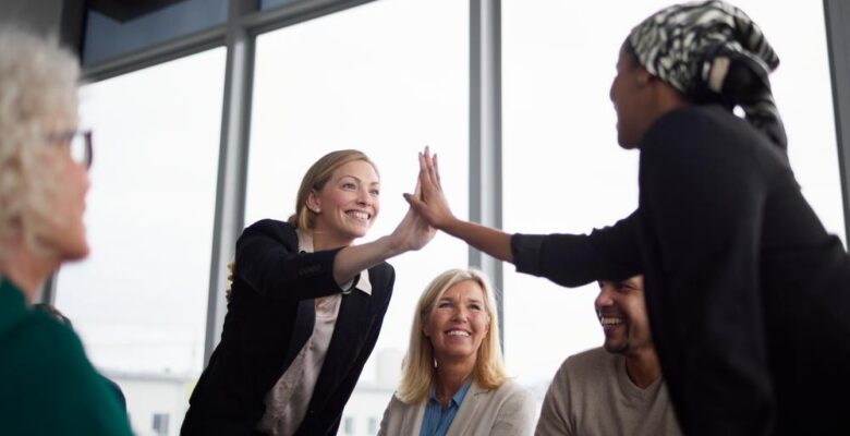 kollegor gör high five med sina händer tvärs över ett bord