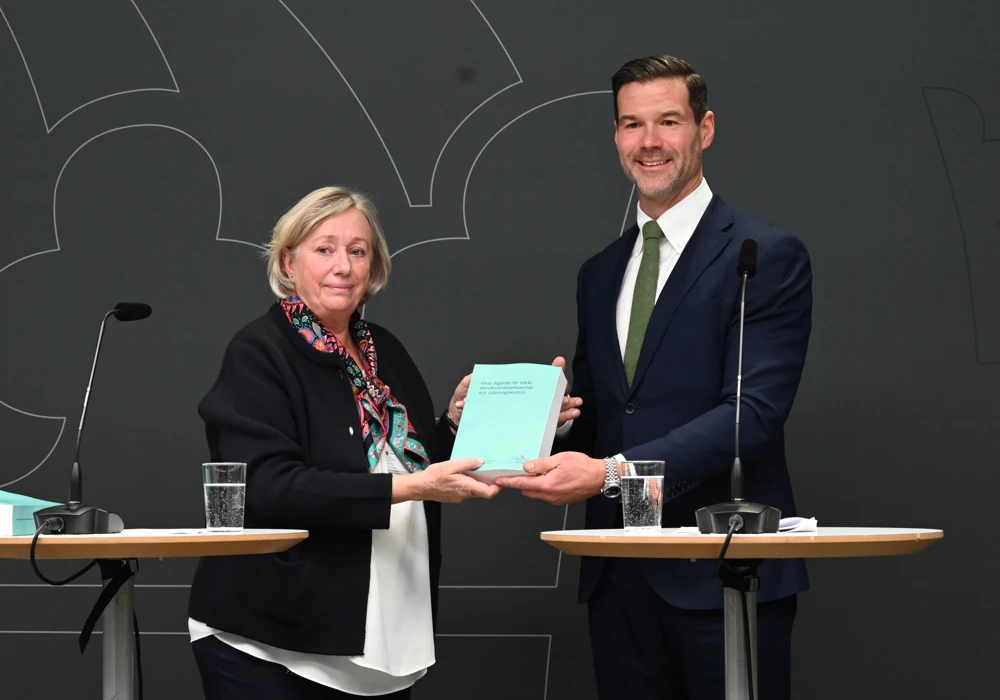Utredaren Anita Linder lämnar över utredning om informationsplikt till migrationsminister Johan Forssell.