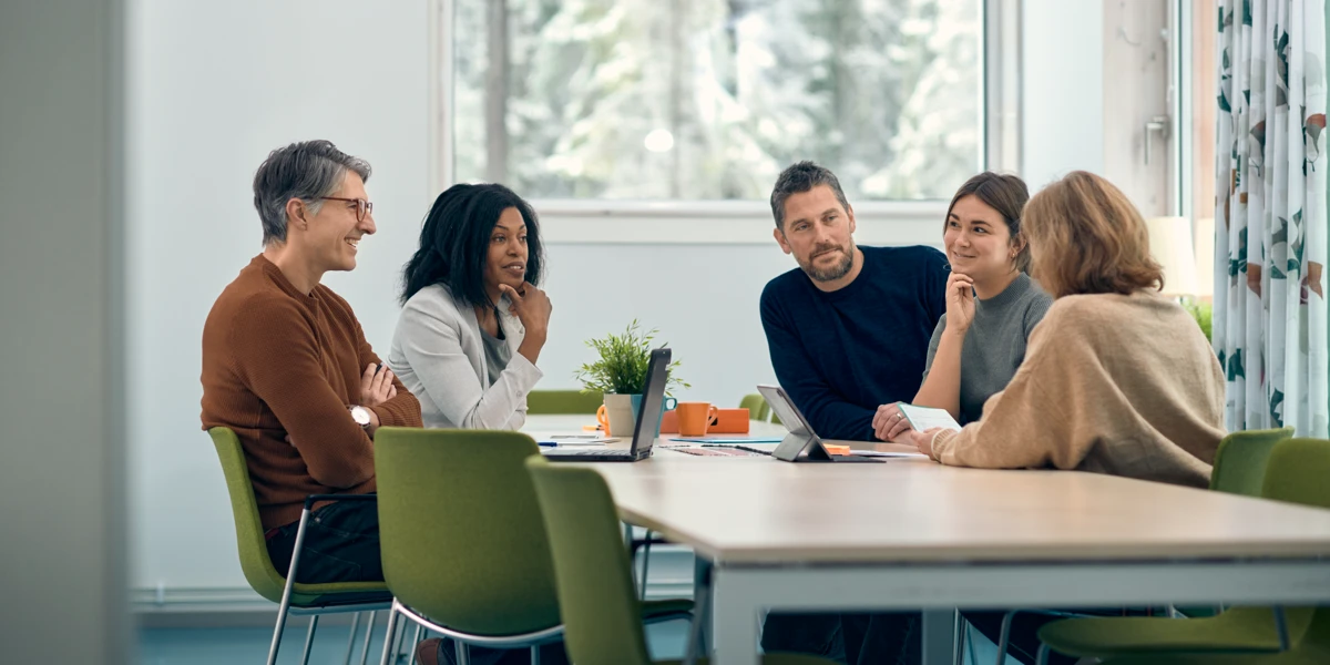 En grupp människor som sitter runt ett bord och pratar.