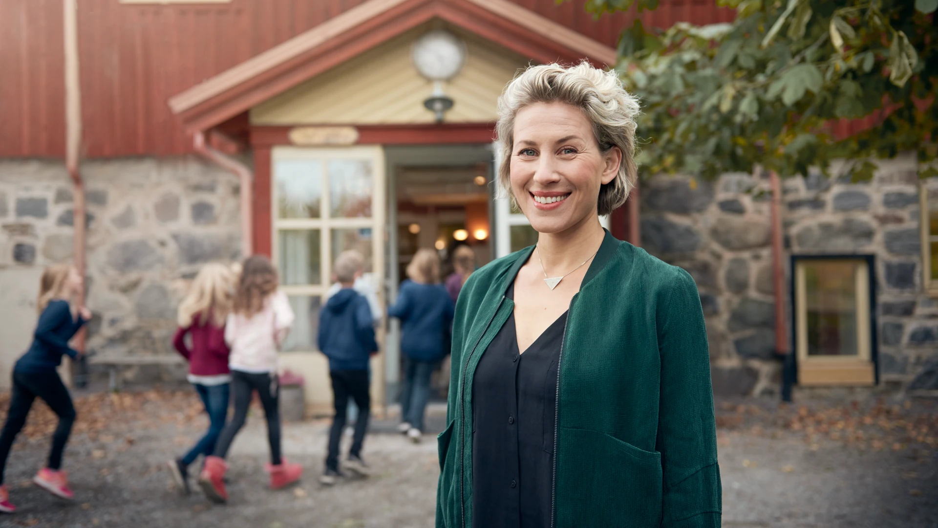 En kvinna står framför en byggnad.
