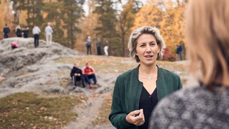 En kvinna som står framför en grupp människor.